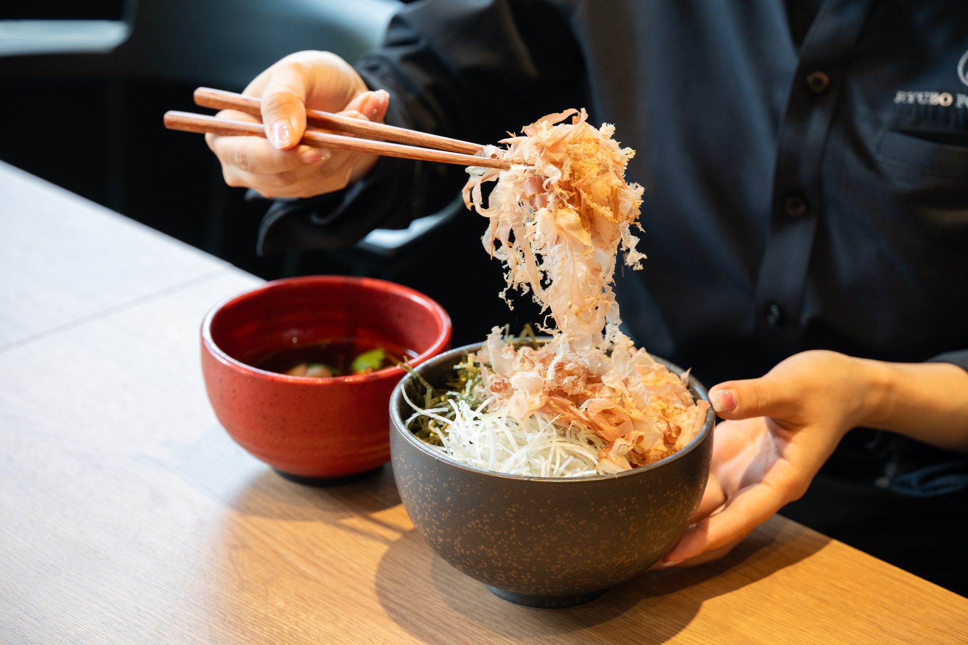 極太蕎麦を辛味つけ汁にくぐらせる
